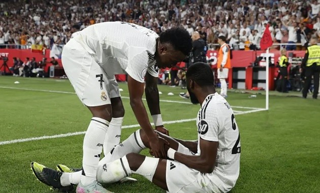 Antonio Rudiger ôm đầu gối sau pha va chạm trong trận đấu với Barcelona.